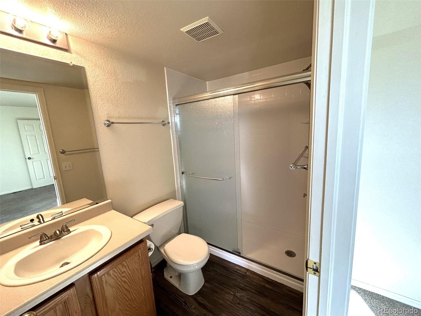 9325 Welby Rd Terrace Denver, CO 80229 - Photo 10 of 21 a bathroom with a granite countertop sink toilet and shower
