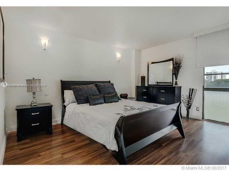 20400 West Country Club Drive, Unit 410 Aventura, FL 33180 - Photo 3 of 7 a bedroom with a bed and wooden floor