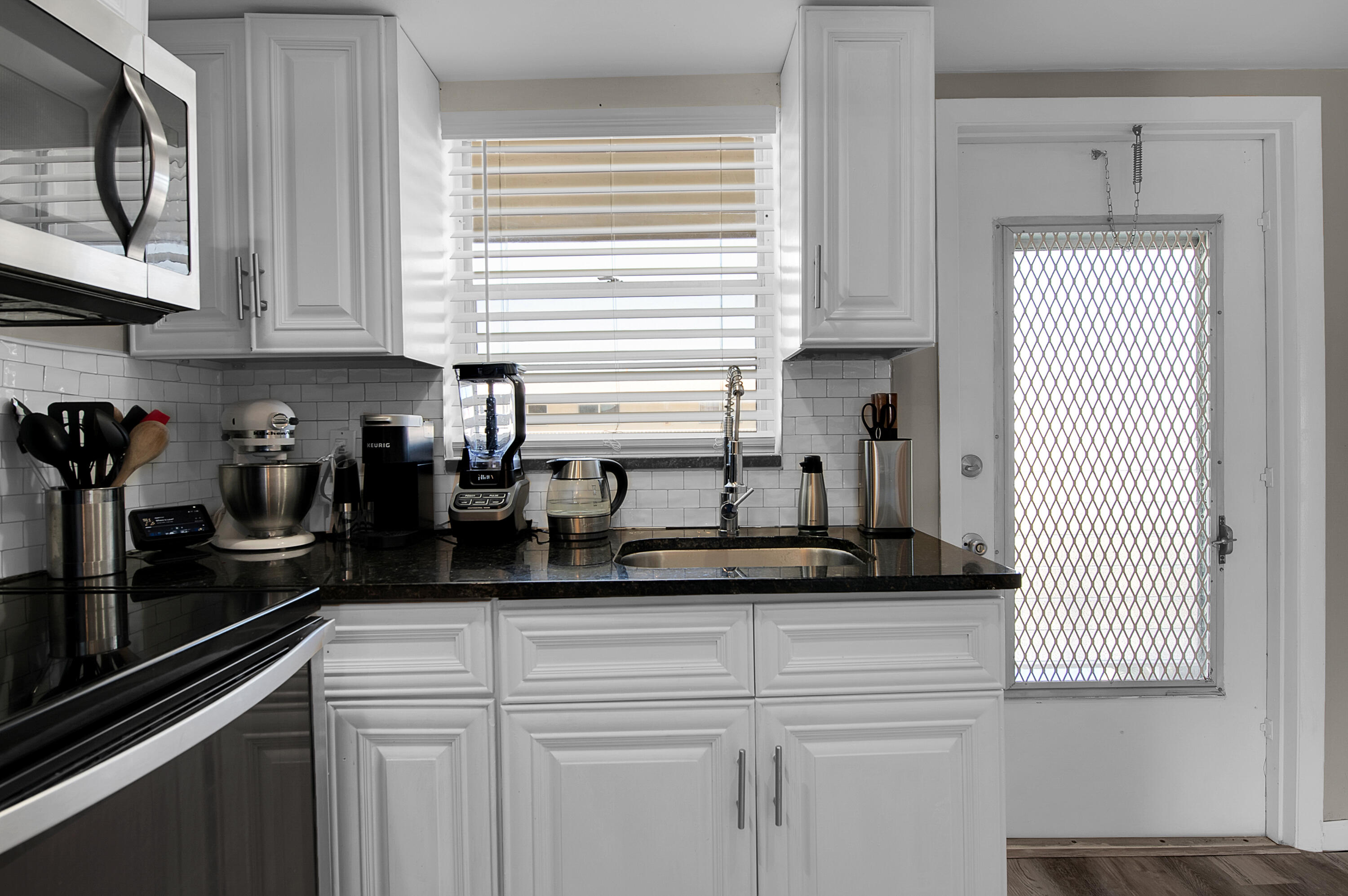 312 Northeast 17th Avenue, Unit 202 Boynton Beach, FL 33435 - Photo 14 of 44 a kitchen with stainless steel appliances granite countertop white cabinets sink and a granite counter top