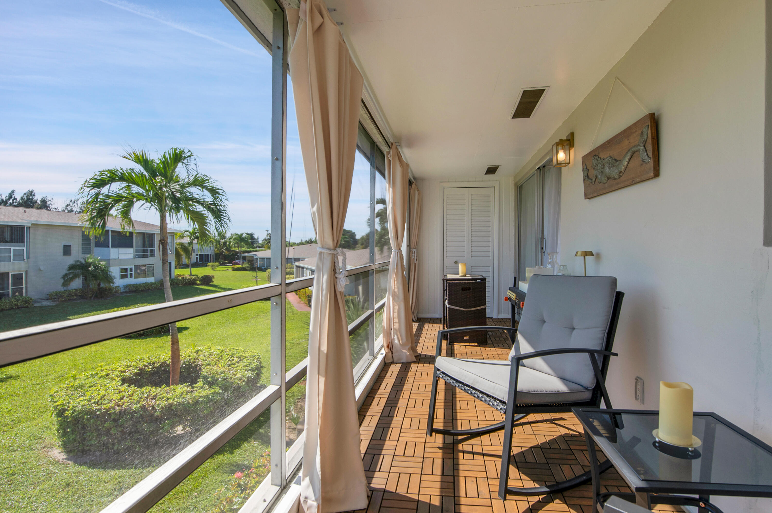 312 Northeast 17th Avenue, Unit 202 Boynton Beach, FL 33435 - Photo 26 of 44 a view of a chairs and table in patio with a lake view