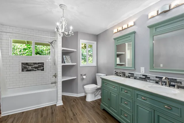 a bathroom with a double vanity sink toilet and a bathtub