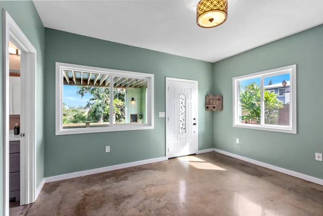 an empty room with window and air conditioner vent