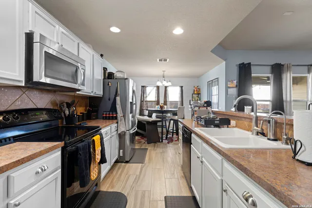a kitchen with counter top space a sink cabinets and appliances