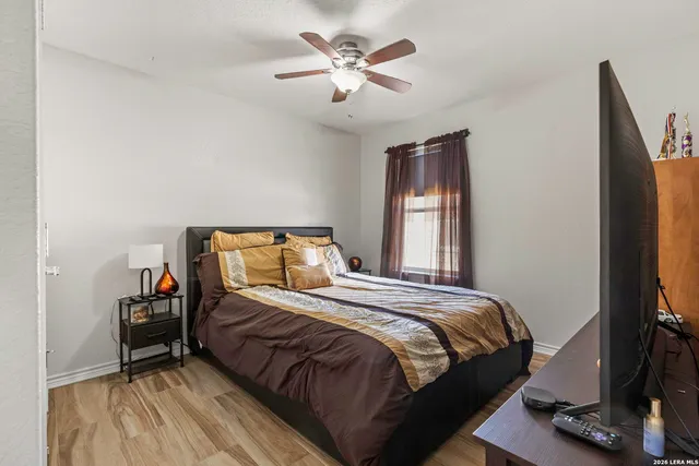 a bedroom with a bed and a flat tv screen on the dresser