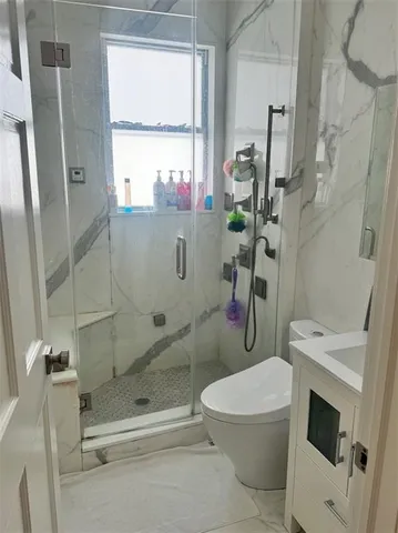 a kitchen with stainless steel appliances kitchen island granite countertop a table chairs in it and wooden floors