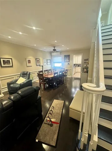 a living room with furniture flat screen tv and kitchen view