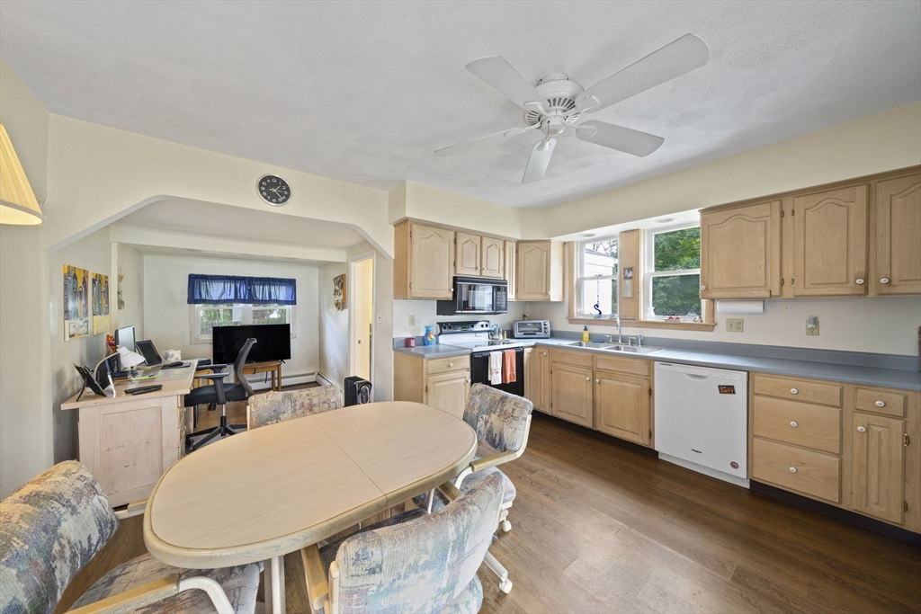 619 North Main Street Mansfield, MA 02048 - Photo 4 of 28 a kitchen with a dining table chairs sink and white cabinets