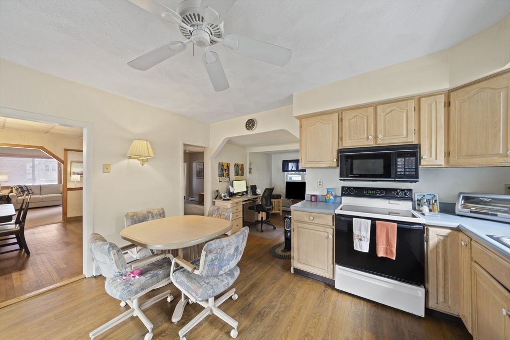 619 North Main Street Mansfield, MA 02048 - Photo 6 of 28 a living room with stainless steel appliances furniture a fireplace a flat screen tv and a window