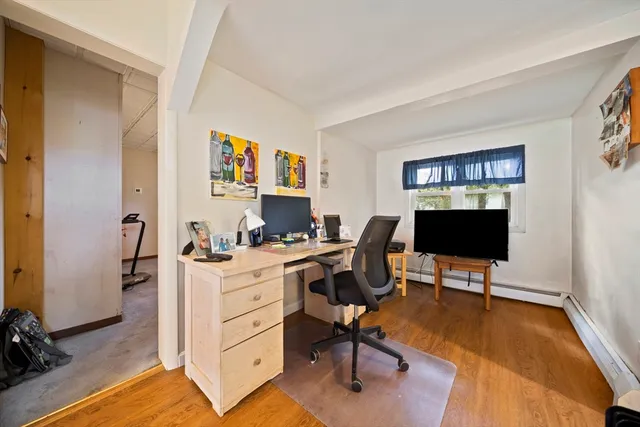 a view of a workspace with furniture and a window