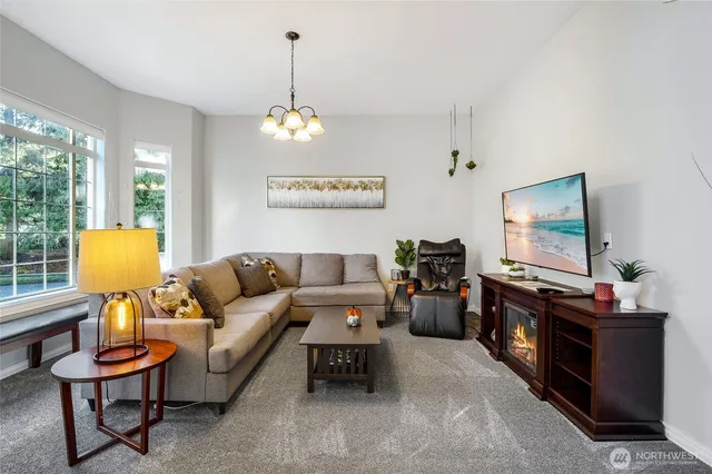 a living room with furniture a flat screen tv and a large window