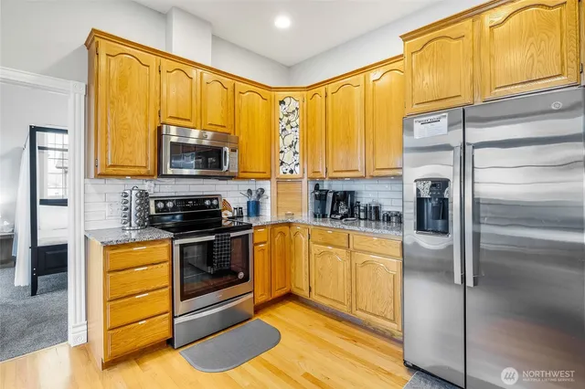 a kitchen with stainless steel appliances a stove top oven and a refrigerator