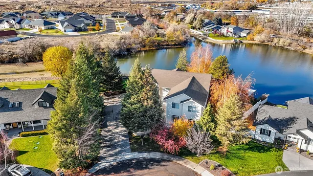 an aerial view of residential houses with outdoor space and lake view