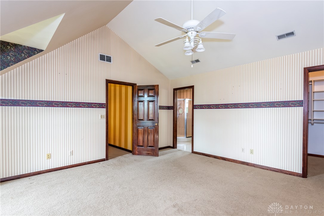9981 Ridge Acres Lane Englewood, OH 45322 - Photo 36 of 73 This spacious bedroom offers comfortable carpeting and a soaring vaulted ceiling for an airy feel.