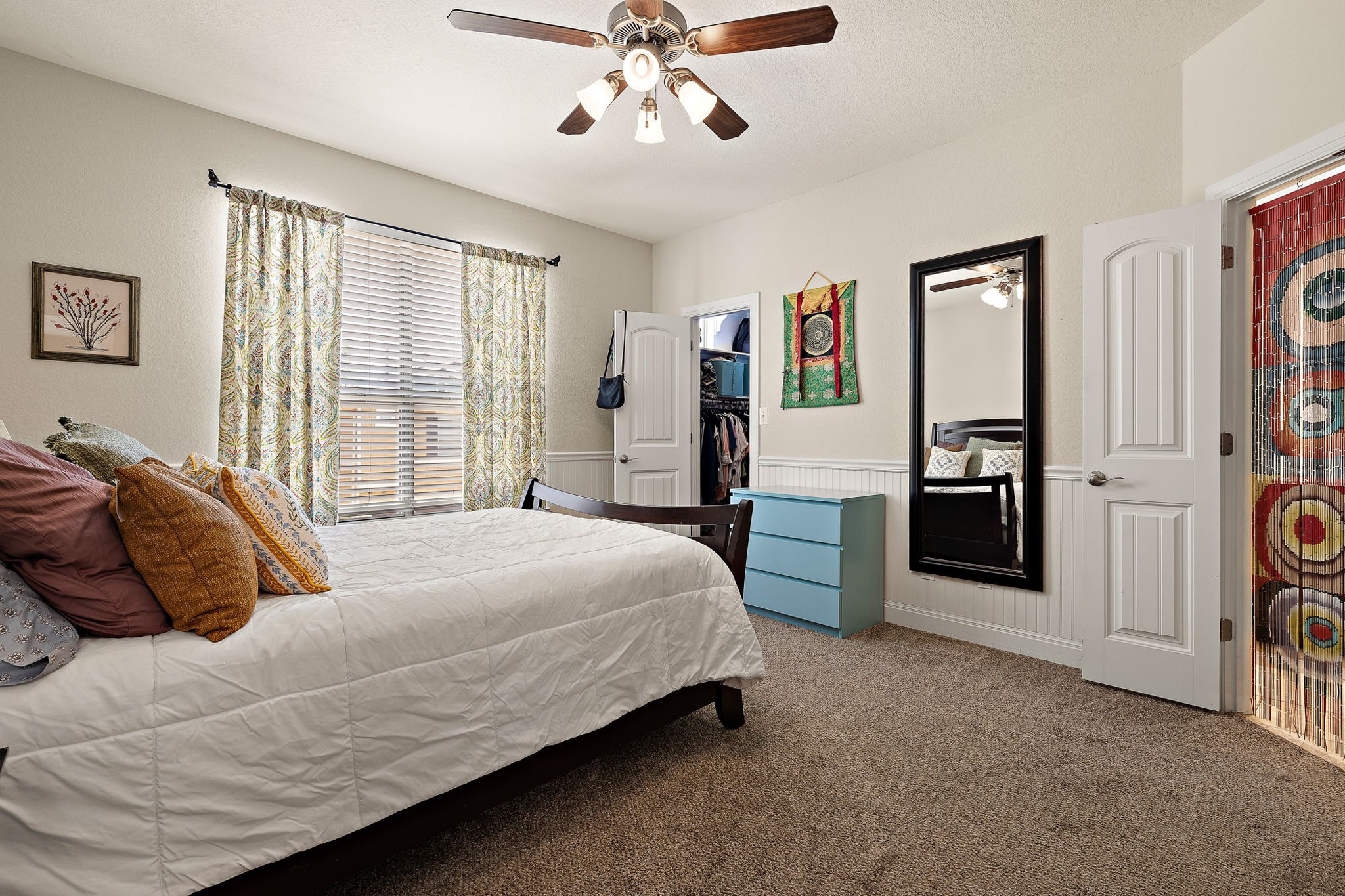 6708 Menchaca Road, Unit 10 Austin, TX 78745 - Photo 15 of 28 Carpeted room featuring a ceiling fan with light fixture, window with blinds and curtains, and white wainscoting