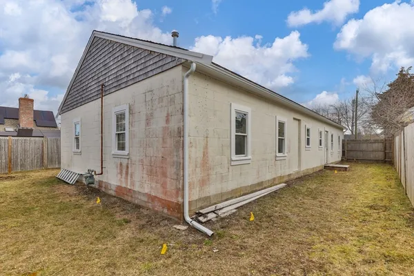 a view of a house with backyard and wooden fence