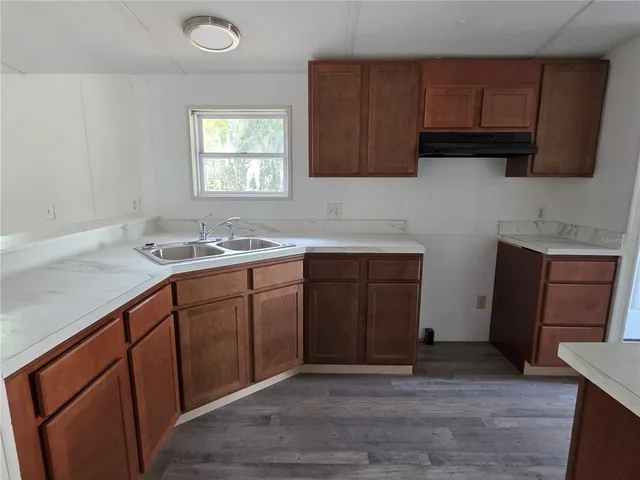 a kitchen with sink refrigerator and window