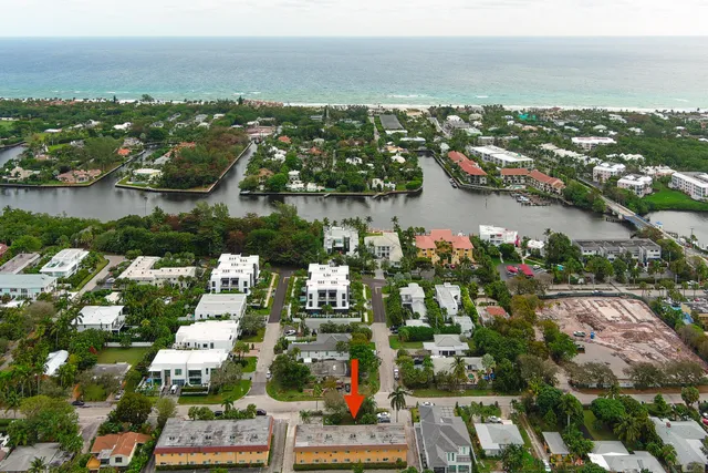 an aerial view of city and lake with trees all around