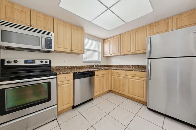 a kitchen with cabinets stainless steel appliances and counter space
