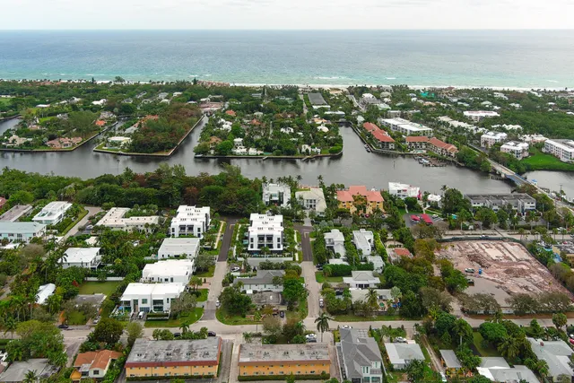 an aerial view of city and lake with trees all around