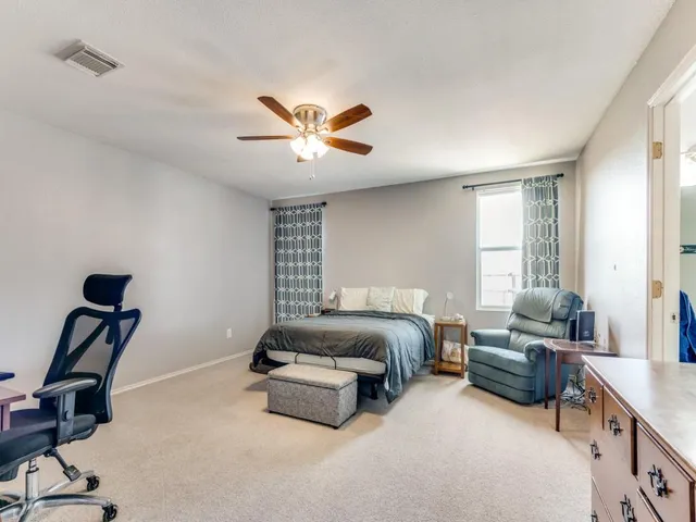 a bedroom with a bed and a chandelier fan