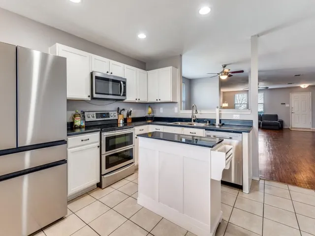 a kitchen with stainless steel appliances granite countertop a refrigerator sink and stove