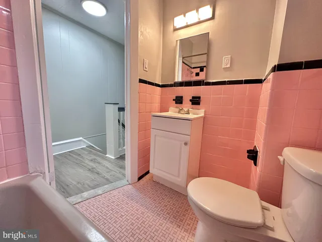 a bathroom with a granite countertop toilet sink and mirror