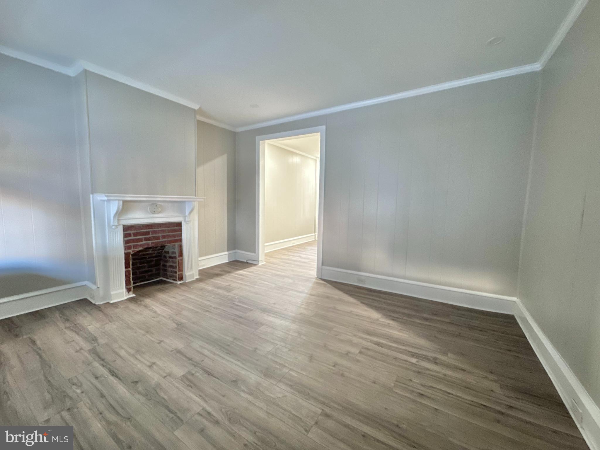 934 North Fallon Street Philadelphia, PA 19131 - Photo 6 of 26 an empty room with wooden floor fireplace and windows
