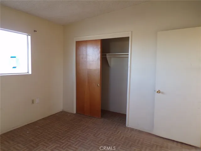 an empty room with closet and windows