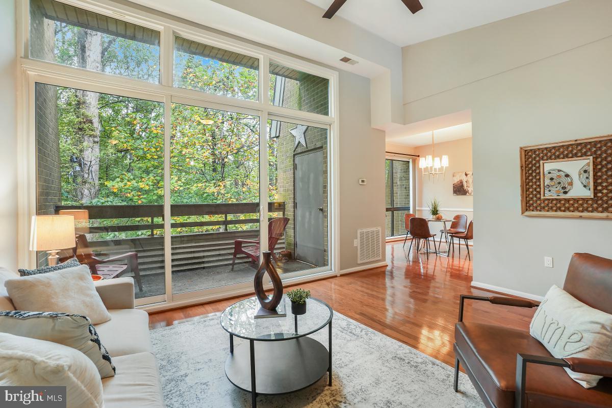 2102 Green Watch Way, Unit 301 Reston, VA 20191 - Photo 11 of 32 a living room with furniture a table and a large window