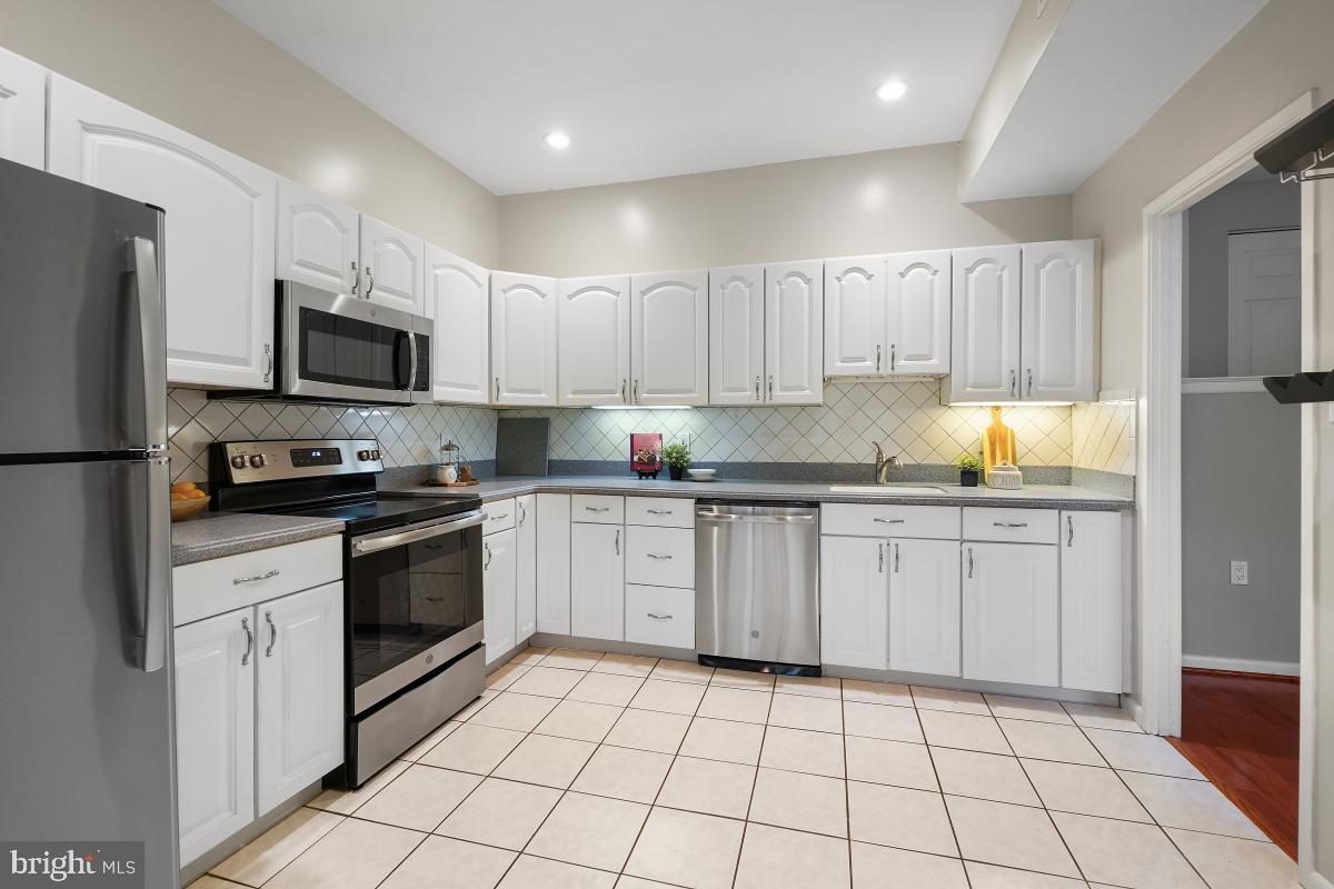 2102 Green Watch Way, Unit 301 Reston, VA 20191 - Photo 15 of 32 a kitchen with granite countertop a sink a stove top oven and refrigerator