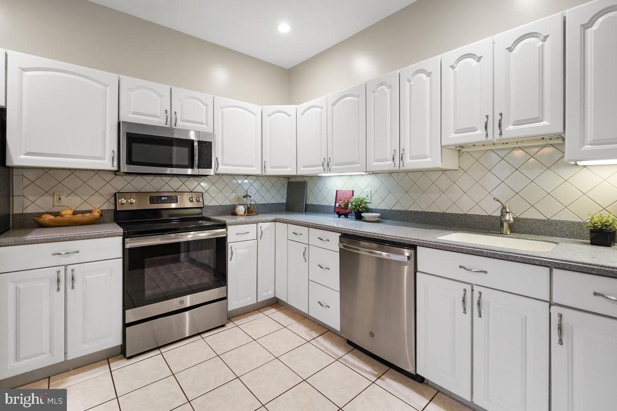 2102 Green Watch Way, Unit 301 Reston, VA 20191 - Photo 16 of 32 a kitchen with white cabinets stainless steel appliances and sink