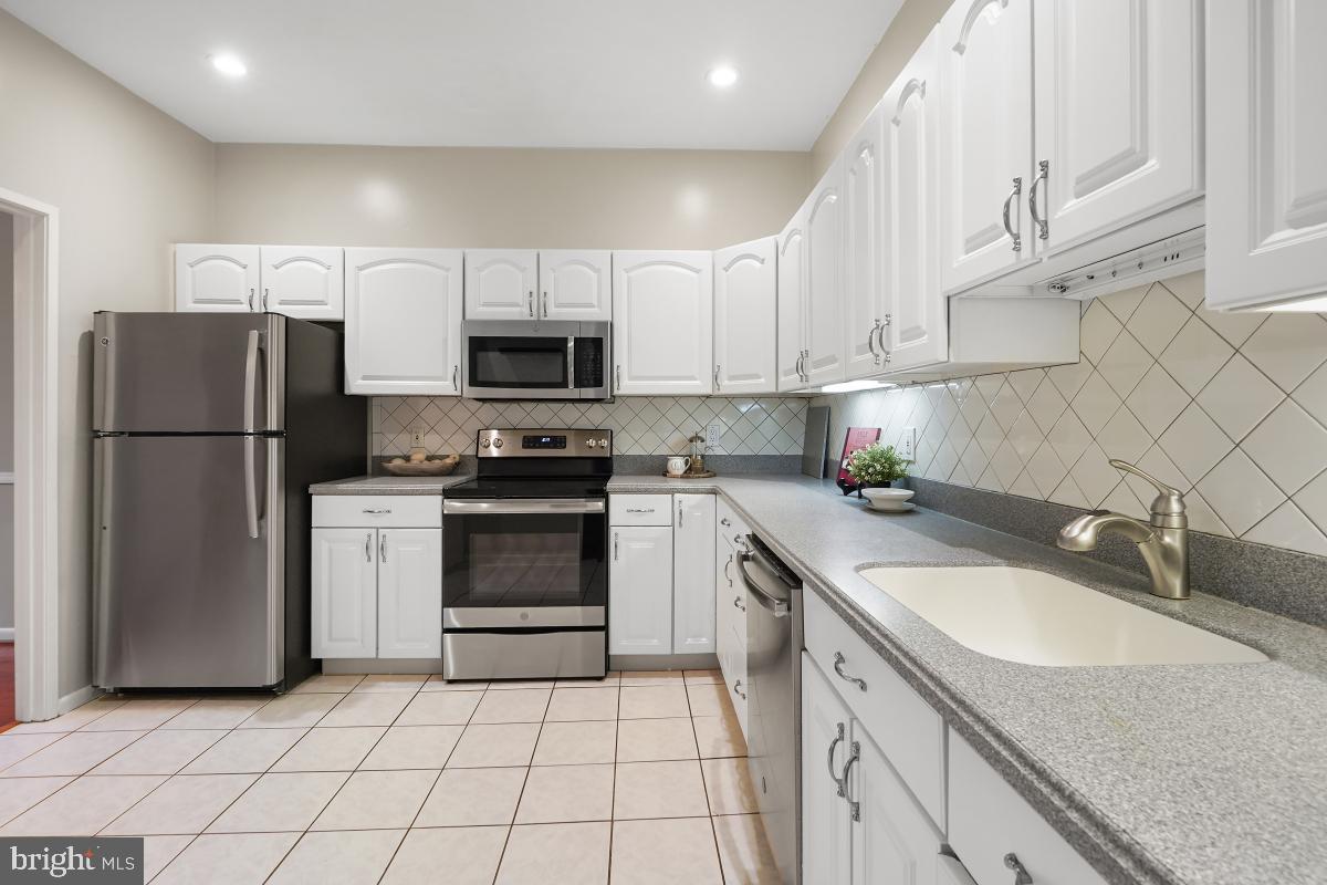 2102 Green Watch Way, Unit 301 Reston, VA 20191 - Photo 17 of 32 a kitchen with granite countertop a sink stove and refrigerator