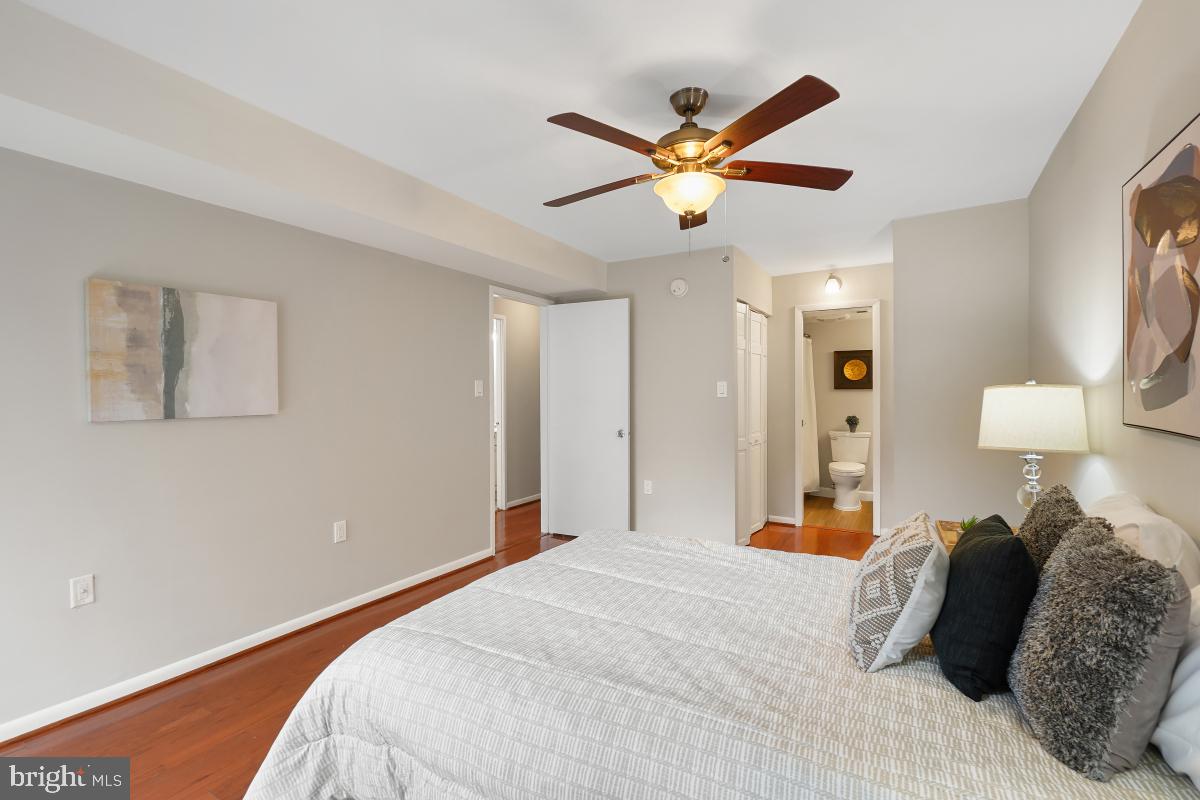 2102 Green Watch Way, Unit 301 Reston, VA 20191 - Photo 25 of 32 a bedroom with a bed and a chandelier