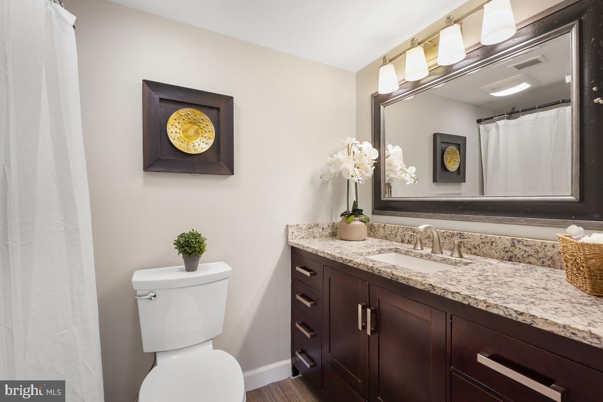 2102 Green Watch Way, Unit 301 Reston, VA 20191 - Photo 27 of 32 a bathroom with a granite countertop toilet sink and mirror