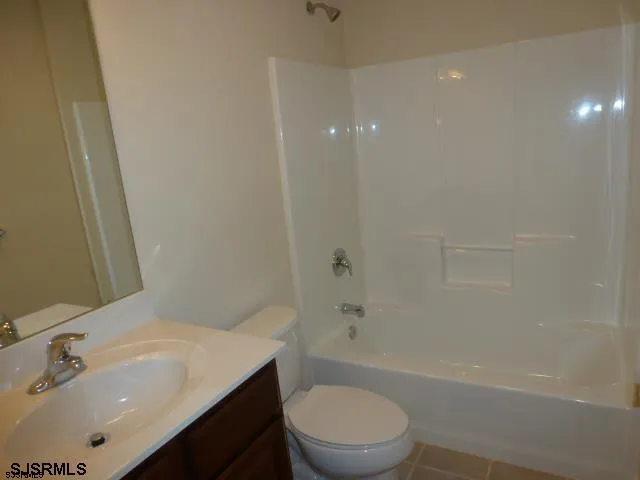 a bathroom with a bathtub shower sink vanity and toilet