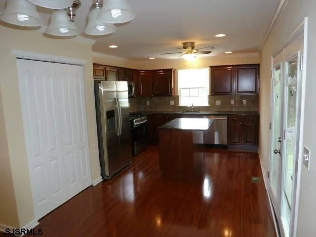a view of a kitchen with a sink stainless steel appliances and cabinets