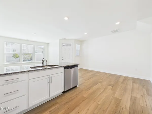 a view of a hallway with wooden floor and entryway