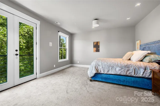 a spacious bedroom with a bed and a large window