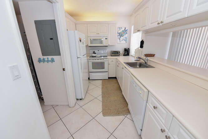 353 Highway 1, Unit F306 Jupiter, FL 33477 - Photo 7 of 43 a kitchen with white cabinets and white appliances