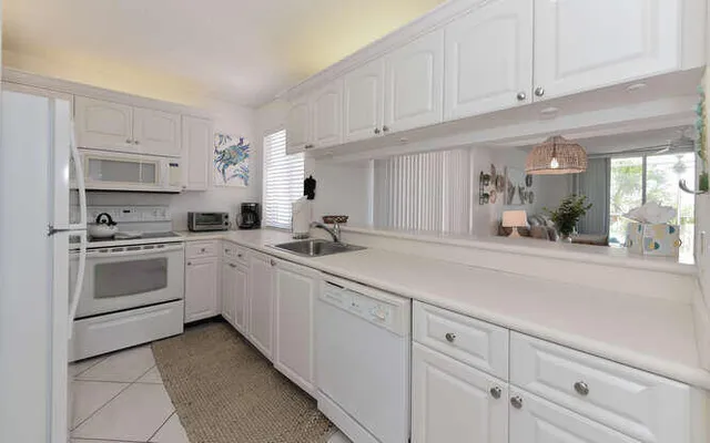 a kitchen with a sink a refrigerator and cabinets