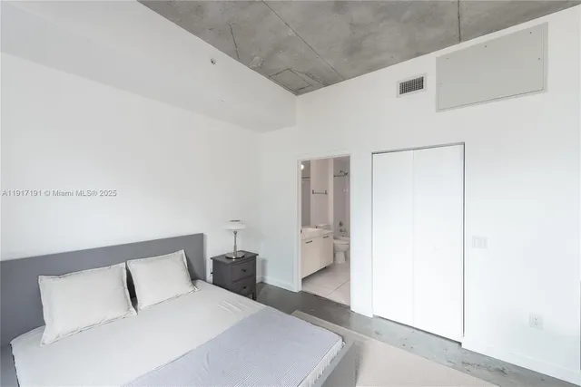 a bedroom with a bed and a white wall