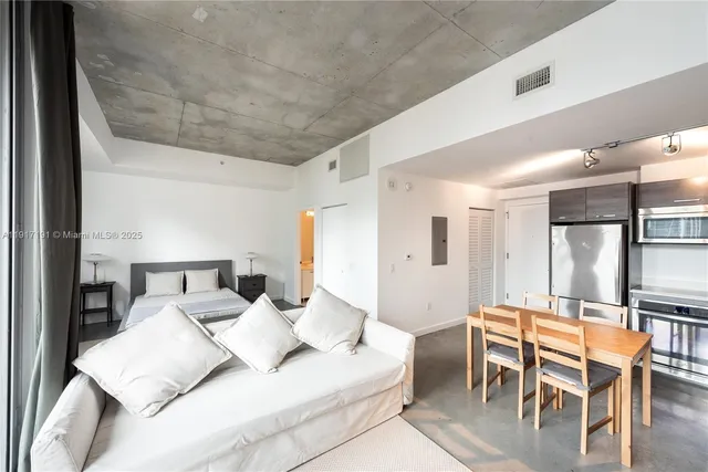 a living room with furniture and a dining table with kitchen view