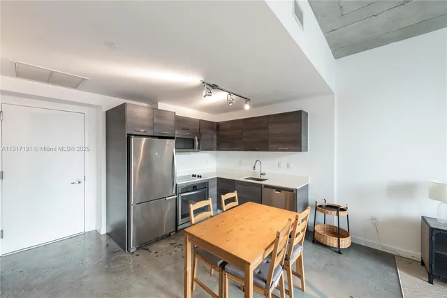 a kitchen with stainless steel appliances a refrigerator and a microwave