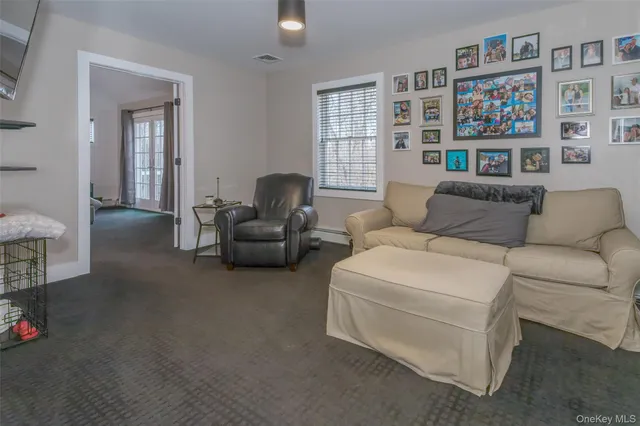 a living room with furniture and a bookshelf with wooden floor