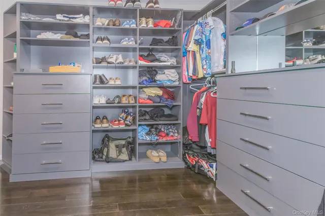 a view of walk in closet with clothes and shoes