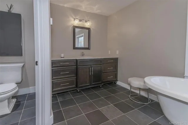 a bathroom with a toilet a sink and mirror