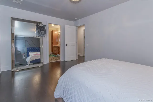 a spacious bedroom with a bed and a mirror