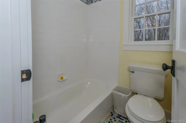 a white toilet sitting next to a bath tub