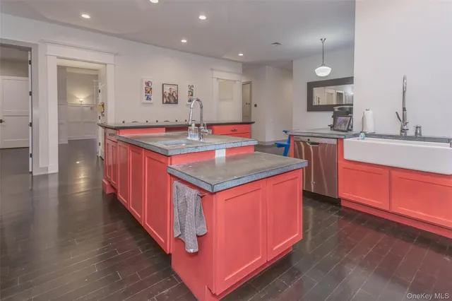 a kitchen with kitchen island stainless steel appliances a sink stove and wooden floor