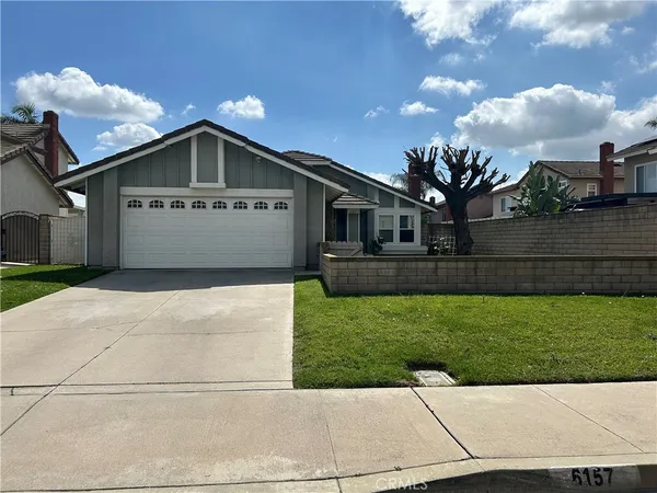 a front view of a house with a garden and yard